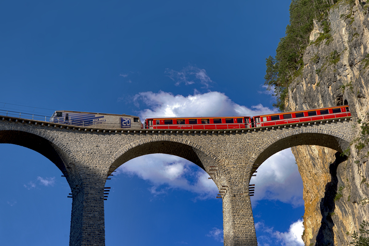 Aus dem Mausloch kommt die Ge 4/4 III mit einem Re aus St.Moritz nach Chur herausgefahren auf das Landwasserviadukt in Filisur,Bild vom 23.6.2016