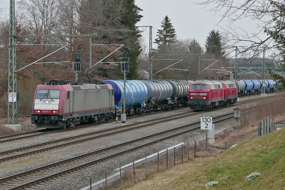 Aus Richtung Memmingen kommend fhrt 185 591-5 mit einem Kesselwagenzug am 03.03.2021 in Hergatz an 218 491-9 und 218 494-3 vorbei in Richtung Lindau-Reutin.