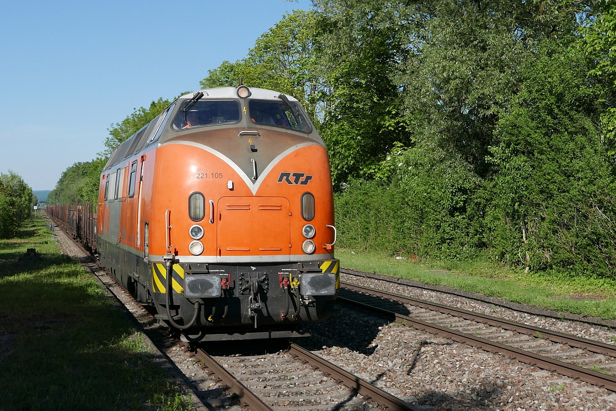 Aus Richtung Ulm kommend fährt 221 105 der RTS mit den mit Schienen und Schwellen beladenen Wagen zur Baustelle in Friedrichshafen Gbf. Am 22.05.2017 wurde an der Haltestelle Friedrichshafen Löwental auf den Auslöser gedrückt.