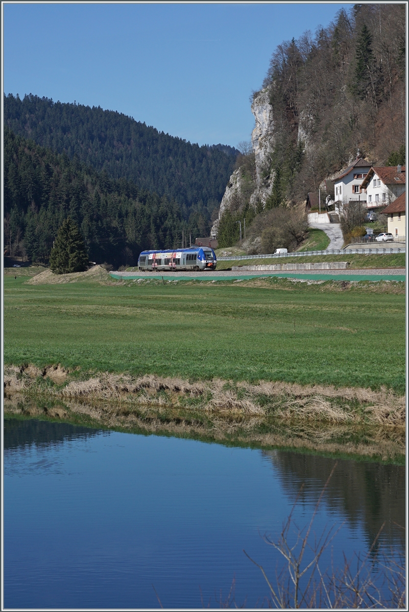 Aus der sich öffnenden Enge des Tales des Doubs kurz vor Pont de la Roche fährt ein SNCF X 76500 Triebzug als TER 18109 von Besançon Viotte nach La Chaux de Fonds in Richtung Morteau. 

16. April 2022