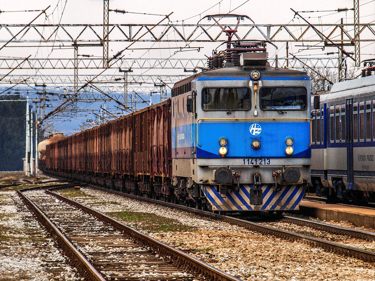 Aus Slowenien kommend donnerte am 13.03.2015. die 1141 213 mit ihrem aus unzähligen leeren E-Wagen zusammengesetzten Güterzug durch den Bahnhof von Zapresic in Richtung Zagreb Verschiebebahnhof. Obwohl Elektrolokomotiven der Teilreihe 1141 200 eine Höchstgeschwindigkeit von 140 km/h erreichen, wurden sie der Güterverkehrssparte (HZ Cargo) zugewiesen.