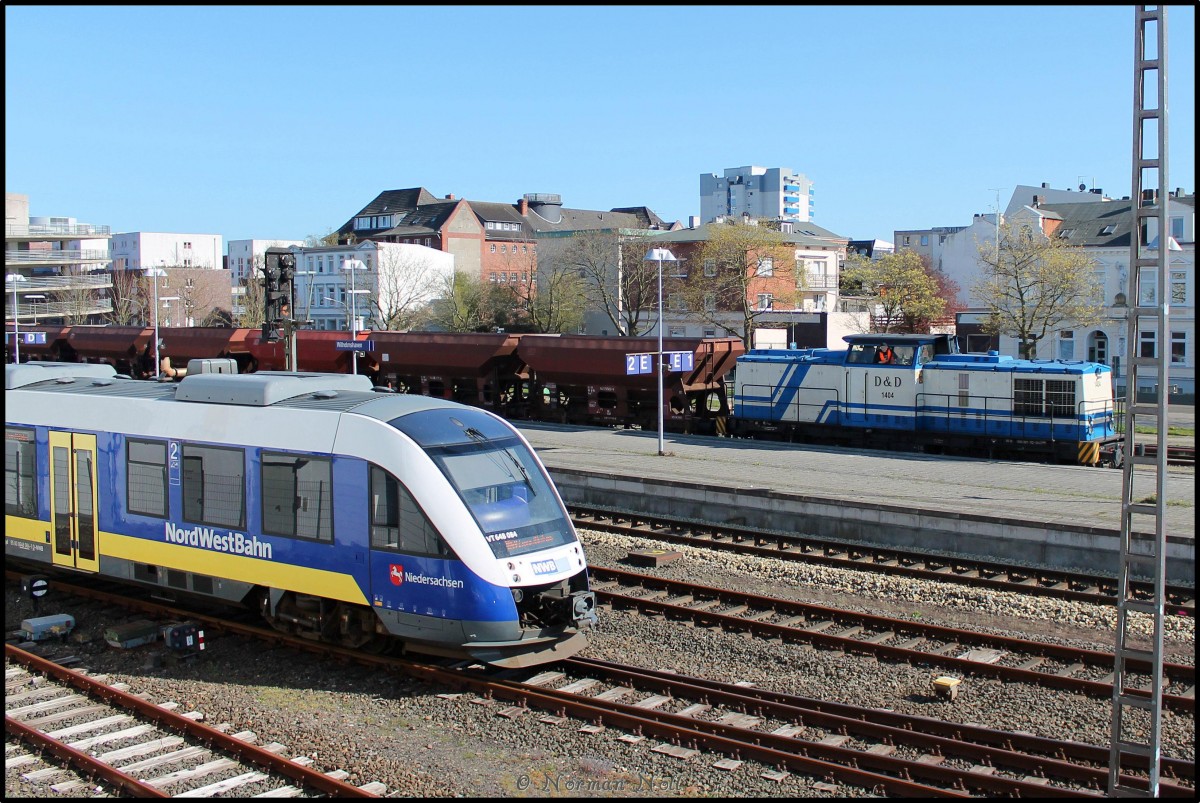 Ausfahrende RB59 der NWB von Wilhelmshaven nach Esens, im Hintergrund die 203 221-7 mit Schüttgutwagen bei der Sanierung des Gleis 1. 23/04/2015