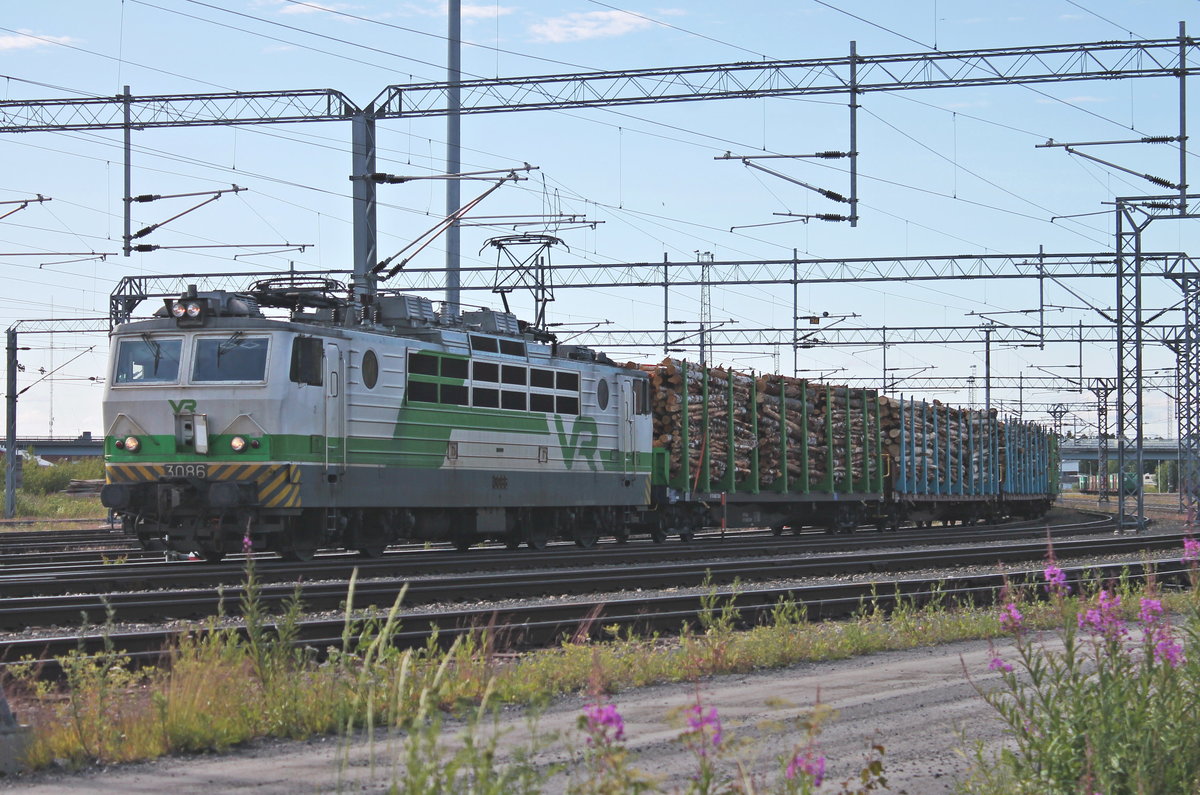 Ausfahrt am Morgen des 09.07.2019 von Sr1 3086 mit einem Holzzug aus dem Güterbahnhof von Oulu in Richtung Personenbahnhof/Norden.