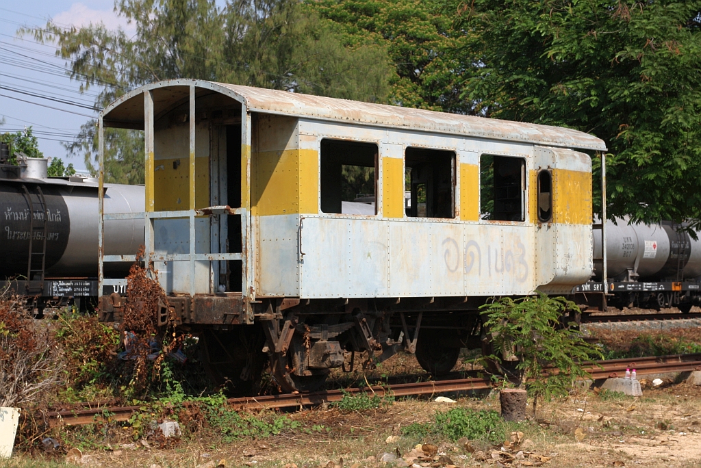 Ausgemustert steht der พ.ห.15021 (พ.ห.=B.V./Brake Van, Taipeh Railway Workshop / Taiwan, Bauj. 1965) am 24.März 2023 auf einem isolierten Gleisstück zwischen Bahntrasse und Straße bei der Nakhon Lampang Station.