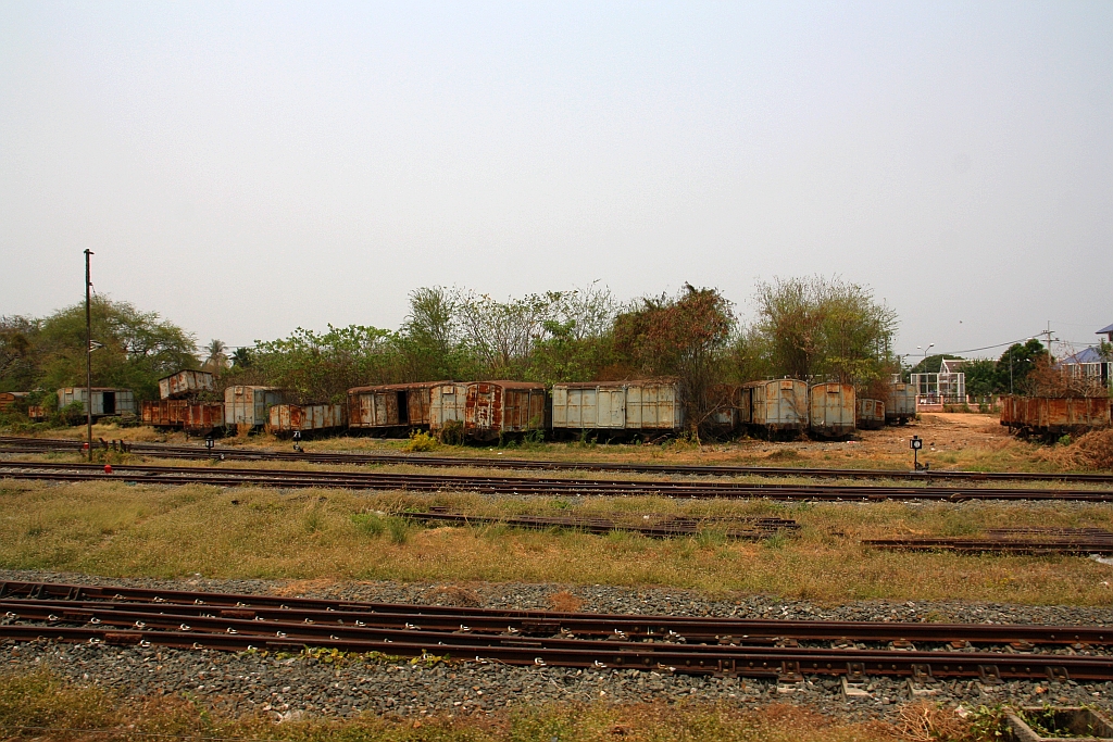 Ausgemusterte ต.ญ. (ต.ญ.=C.G./Covered Goods Wagon) und ข.ส. (ข.ส. =H.S./High Sided Wagon) warten abseits der Gleise in der Uttaradit Station auf ihr weiteres Schicksal. Bild vom 28.März 2023.
