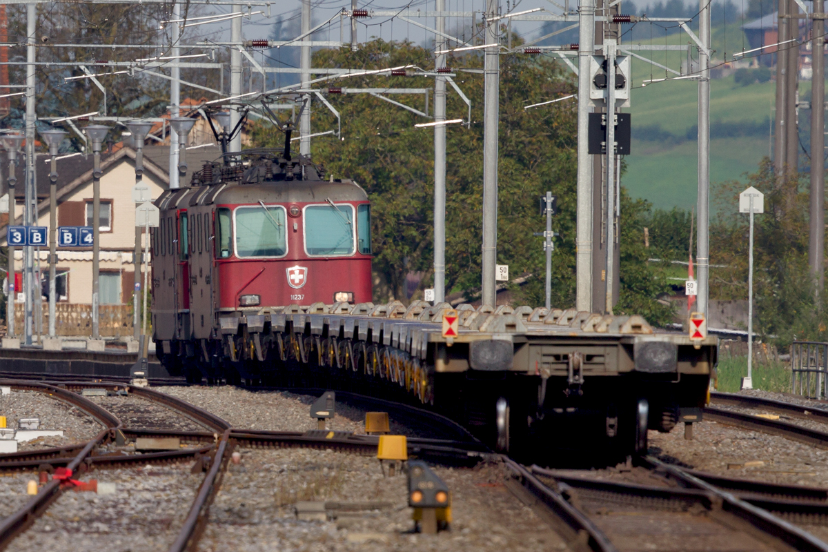 Aussergewöhnlicher Nachschuss auf die beiden Re 4/4 II Loks 11167 in Front und die 11237 die hier sichtbar ist,mit leeren Niederflurwagen durchfahren sie den Bf Reichenburg Richtung Zürich.Bild vom 4.9.2014