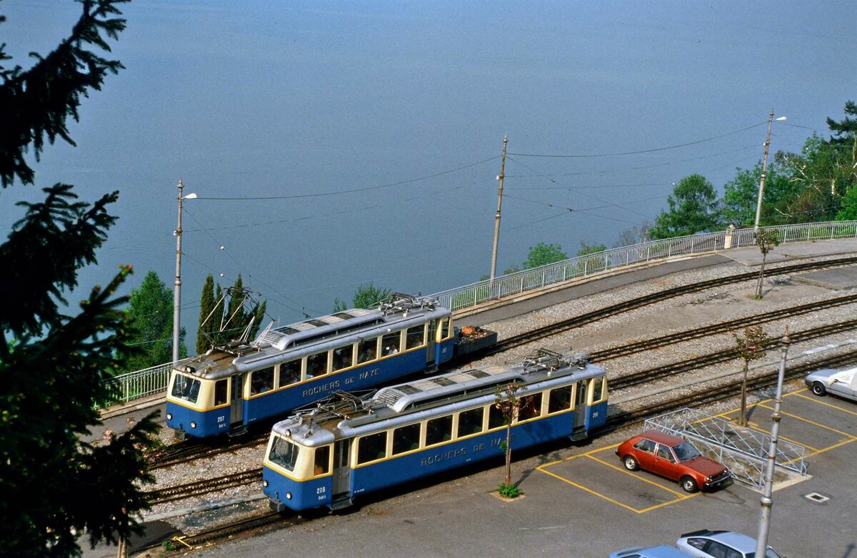 Ausweichstation und auch Zwischenstation Glion auf dem Schienenweg der Schweizer Privatbahn Montreux-Glion. Ist der Genfer See wirklich so nah? Zwei Zahnradwagen der Baureihe Bhe 2/4 begegnen sich. 
Datum: 19.05.1986