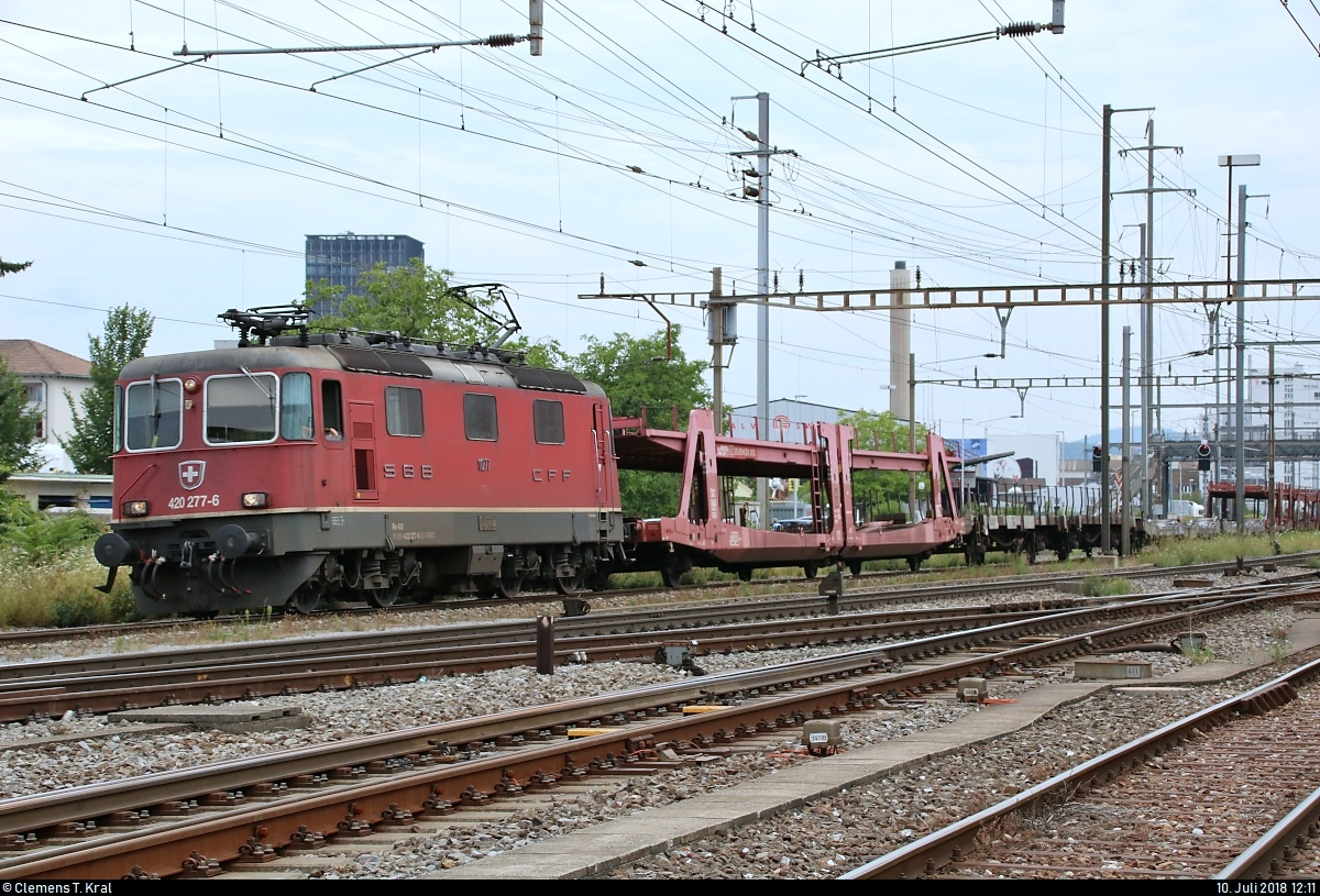 Autotransportzug (leer) mit Re 4/4 II 11277 (420 277-6) SBB durchfährt den Bahnhof Pratteln (CH) in westlicher Richtung.
Aufgenommen von der Güterstrasse.
[10.7.2018 | 12:11 Uhr]