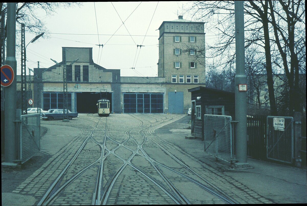 AVG Straßenbahn Augsburg__Zufahrt zum Betriebshof 'Rotes Tor'. Der älteste Kern des Anlagenkomplexes ist die historische, später erweiterte Bahnhofshalle des Bahnhofs Augsburg. Dieser wurde 1839 als Endbahnhof der Bahnstrecke München–Augsburg gebaut. Die Bahnhofshalle gilt als ältestes erhaltenes Empfangsgebäude einer deutschen Großstadt. Sie wurde aber nur wenige Jahre in dieser Funktion genutzt, diente lange als Militärreithalle, bevor sie 1920 in ein Straßenbahndepot umgebaut wurde [wikipedia].__09-03-1974 