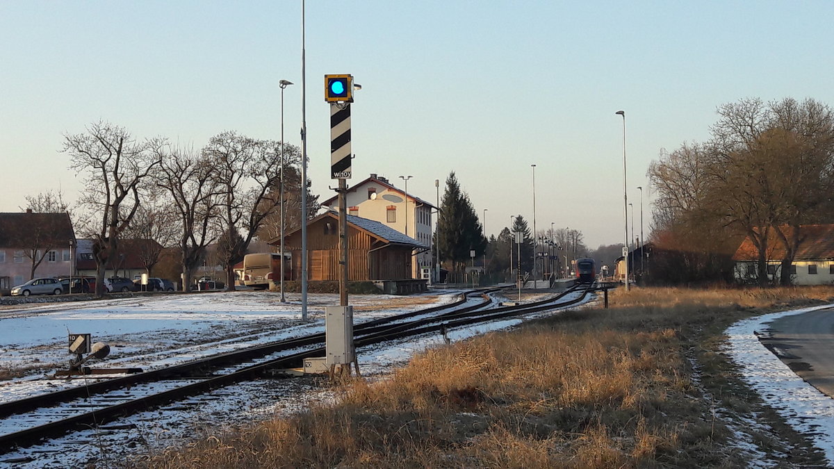 Bad Radkersburg, Ausgangsbahnhof der 31 km langen Radkersburger Bahn nach Spielfeld, 2017-01-20
Auf dem Bild: Ein Weichenüberwachungssignal.Ein blaues Licht auf einer
schwarzen quadratischen Tafel mit gelbem rückstrahlenden Rand.
Der Signalmast zeigt schräg nach rechts steigende schwarze Streifen auf weißem
rückstrahlendem Grund.
Das Signal wird für Betriebsstellen mit Rückfallweichen verwendet