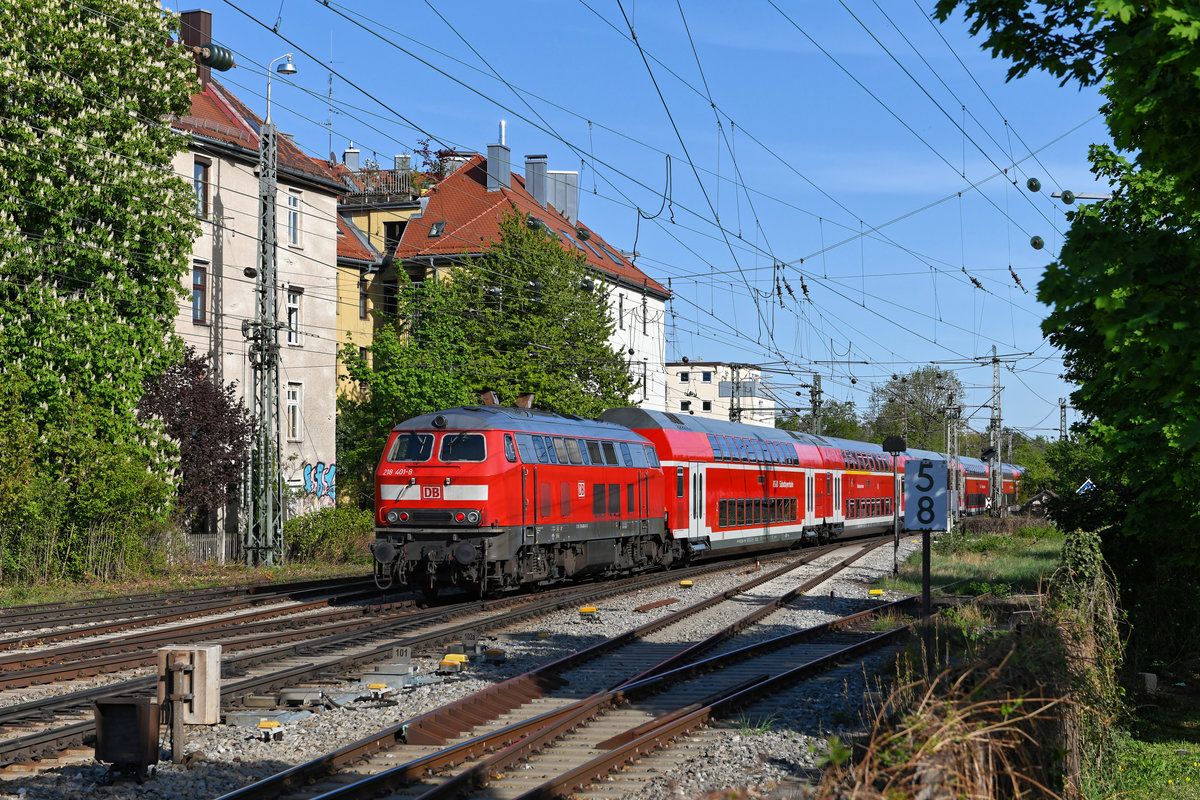  Bäumchen wechsel dich : Im Vergleich zu Aufnahmen zwei Wochen früher zeigt der Vogelkirschenbaum im Hintergrund statt weißer Blüten nun sattes Grün. Dafür ist nun die Kastanie am linken Bildrand aufgeblüht. Auch bei den im Berufsverkehr von und nach Mühldorf eingesetzten 218ern gab es einen täglichen Wechsel. Am 21. April 2020 kam die bestens im Lack stehende 218 401 zum Einsatz, die an diesem Tag als Schlusslok an der RB 27251 fungierte. 