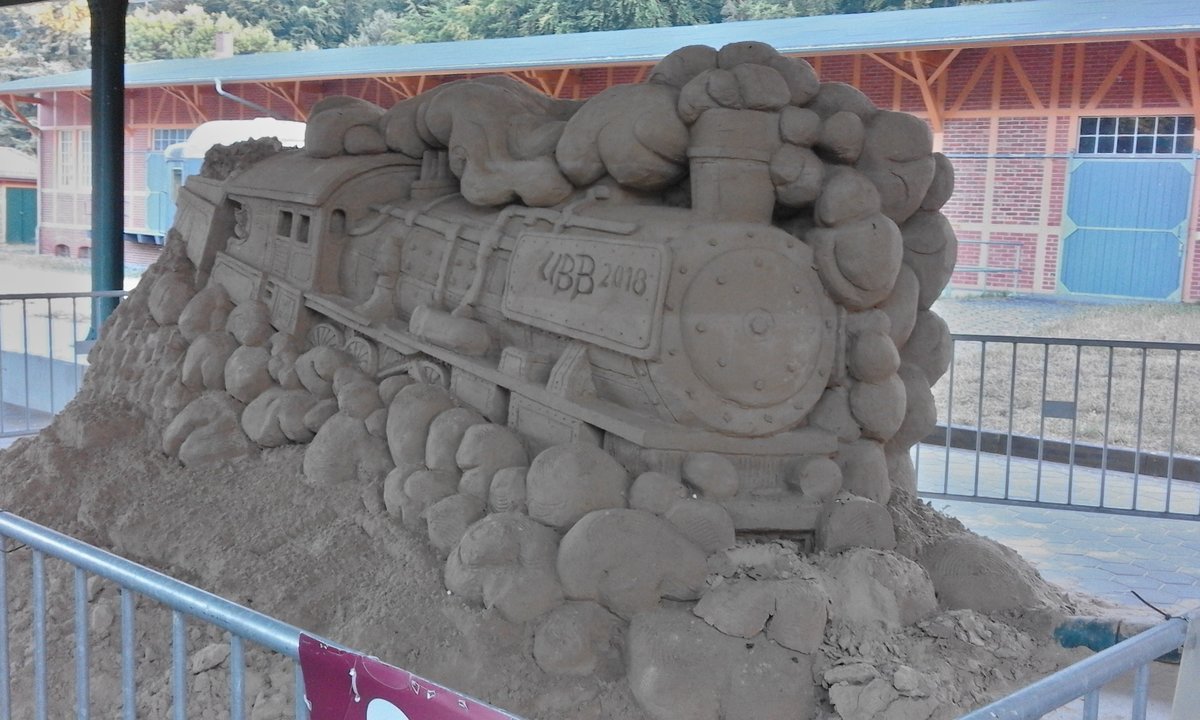Bahn in Sand!
Auf ganz Usedom wird das Sandskulpturenfestival in Ahlbeck beworben. An verschiedenen Standorten wird mit diversen Skulpturen auf das Ereignis hingewiesen, das zum Thema Film einiges zu bieten hat.
Die Dampflok wirbt in Heringsdorf für den Event.

Seebad Heringsdorf, 13.07.2018
