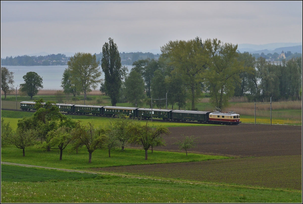 Bahn im Tägermoos - bei Sauwetter. 

Highlight war nicht das Wetter sondern die Re 4/4<sup>I</sup> 10034 auf dem letzten Teilstück der Sonderfahrt Zürich-Schaffhausen-Arbon. Im Hintergrund St. Georg, Teil des Unesco-Weltkulturerbes auf der Reichenau. Mai 2014.