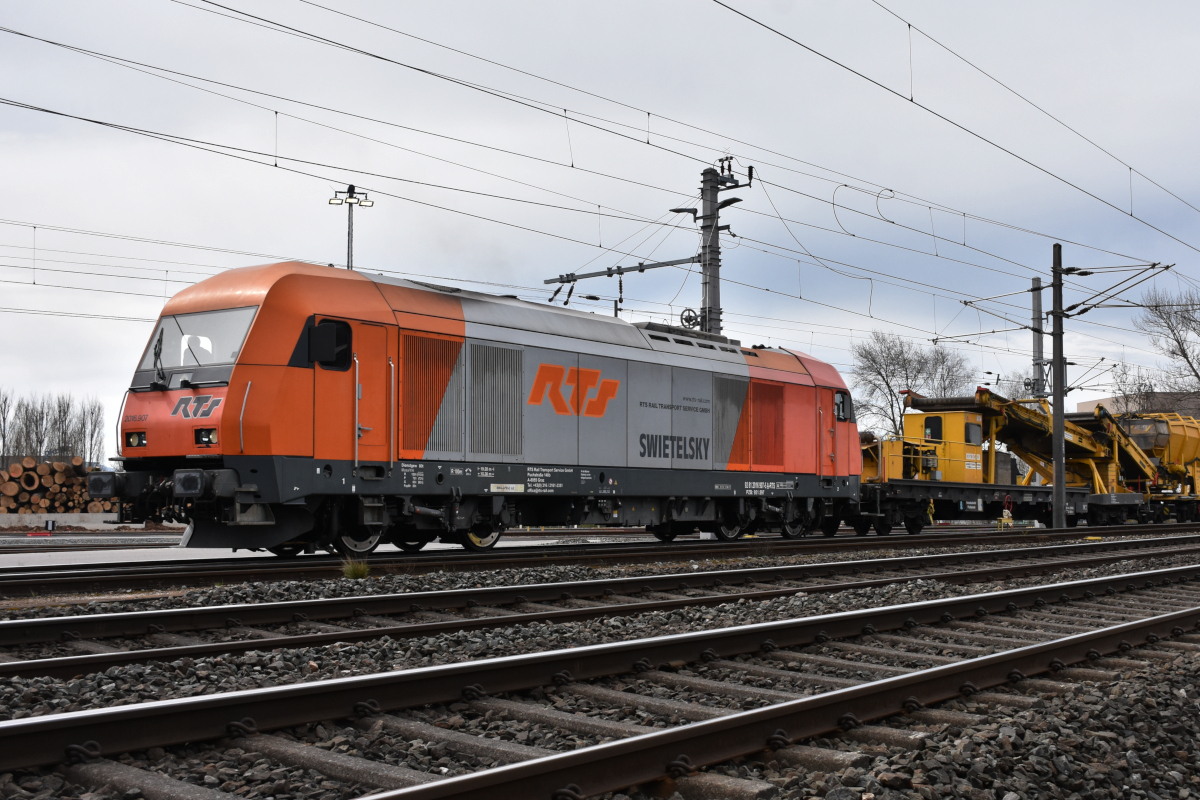 Bahnbau in Vorarlberg: Bauarbeiten zwischen Lauterach und Hard (Verlegung eines 2. Gleises) sorgen dafür, dass wieder Dieselfahrzeuge in Vorarlberg zu sehen sind - hier die 2016 907 der Rail Transport Service GmbH (RTS) mit ihrem Bauzug im Bereich Güterbahnhof Wolfurt am 09.04.2021. Fotostandort: am öffentlichen Weg, über den Zaun fotografiert.