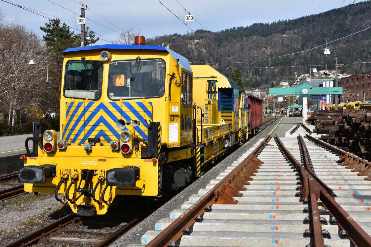 Bahnbau in Vorarlberg: Die ÖBB nutzen die Streckensperre im Zuge der Bauarbeiten zwischen Lauterach und Hard, um gleichzeitig auch im Bahnhof Bregenz die nicht mehr zeitgemäßen Holzschwellen durch Betonschwellen zu ersetzen (als erster Schritt in Richtung Bahnhofsneubau). Ganz rechts warten die Holzschwellen auf den Abtransport. Links steht Oberbauwagen 9185-002 der Bahnbau Wels. Was mich gewundert hat: Der Bahnsteig ist trotz Bauarbeiten und Schwellenlager frei begehbar, es gibt weder Hinweisschilder noch Absperrungen! (09.04.2021)