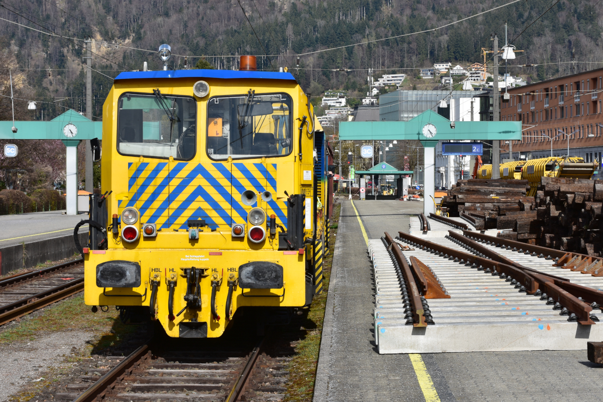 Bahnbau in Vorarlberg: Die ÖBB nutzen die Streckensperre im Zuge der Bauarbeiten zwischen Lauterach und Hard, um gleichzeitig auch im Bahnhof Bregenz die nicht mehr zeitgemäßen Holzschwellen durch Betonschwellen zu ersetzen (als erster Schritt in Richtung Bahnhofsneubau). Ganz rechts warten die Holzschwellen auf den Abtransport. Links steht Oberbauwagen 9185-002 der Bahnbau Wels. Der Bahnsteig ist trotz Bauarbeiten und Schwellenlager frei begehbar, es gibt weder Hinweisschilder noch Absperrungen! (09.04.2021)