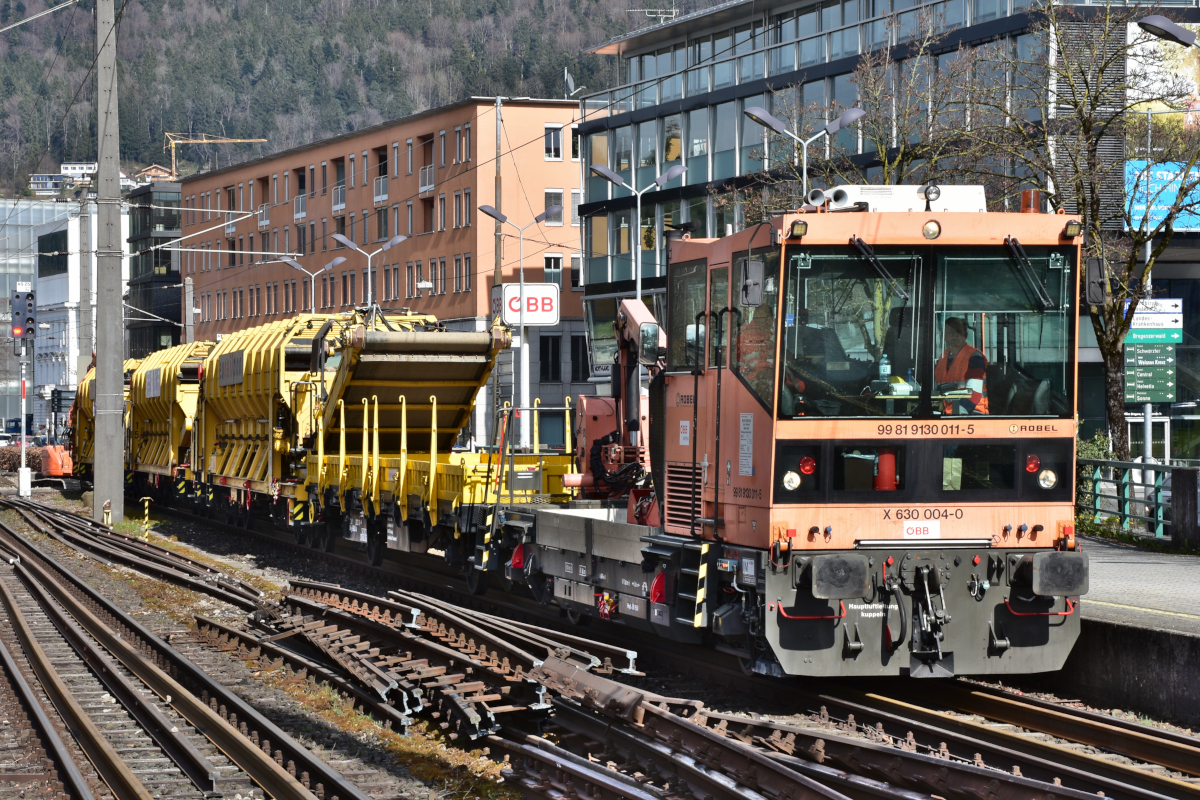 Bahnbau in Vorarlberg: Die ÖBB nutzen die Streckensperre im Zuge der Bauarbeiten zwischen Lauterach und Hard, um gleichzeitig auch im Bahnhof Bregenz die nicht mehr zeitgemäßen Holzschwellen durch Betonschwellen zu ersetzen (als erster Schritt in Richtung Bahnhofsneubau). 
ÖBB X630-004 (99 81 9130 011-5) ROBEL am 09.04.2021 mit Schotterzug zum Abtransport des nicht mehr benötigten Materials im Bahnhof Bregenz.