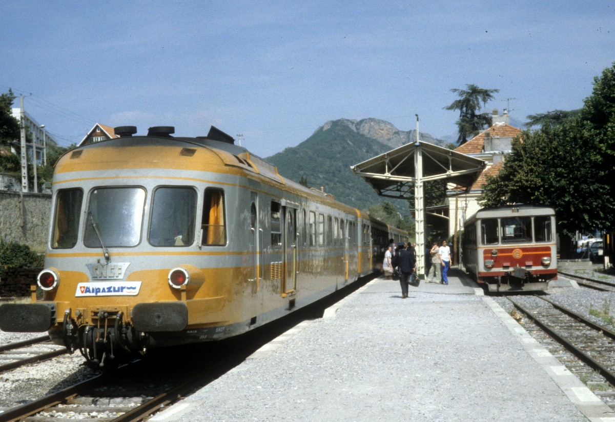 Bahnhof Digne (Département Haute-Provence): Zwei Alpazur-Züge, ein SNCF-Triebzug (RGP) und ein CP-Triebwagen (SY 04), halten am Bahnsteig im Juli 1982.  