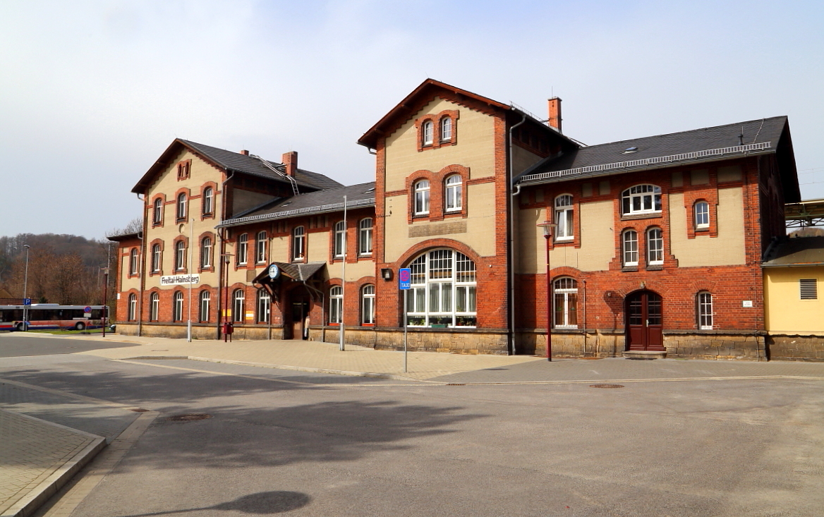 Bahnhof Freital-Hainsberg am 04.04.2016. Wie man hier gut sehen kann, mußte das ehemalige Bahndienstgebäude, welches bis vor ca. 2 Jahren noch links vom Empfangsgebäude stand, im Rahmen der Umgestaltung und Modernisierung des Bahnofumfeldes einem Busparkplatz weichen, was dem einstigen nostalgischen Ambiente des Bahnhofes keinen wirklichen Gefallen getan hat!