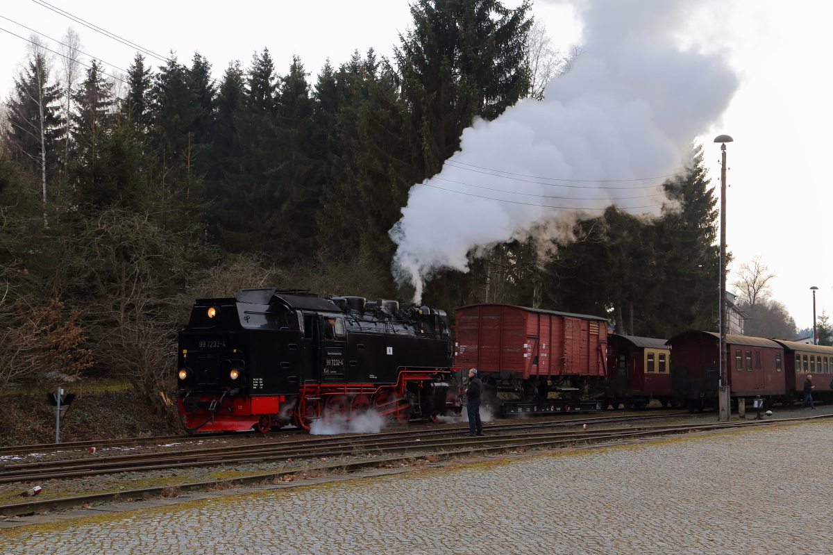 Bahnhof Hasselfelde am frühen Abend des 25.02.2017: Gerade ist P 8965 aus Stiege auf Gleis 2 eingelaufen. Das Bild zeigt den Zugführer desselben im Gespräch mit dem Lokführer von 99 7232, welche mit einem IG HSB-Sonder-PmG auf die Rück-Überführungsfahrt nach Wernigerode wartet. Zuvor wird sie aber erst ihren Zug ein Stück aus dem Bahnhof ziehen, damit die Lok des Planzuges umsetzen kann.