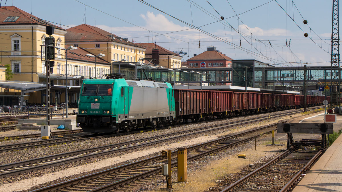 Bahnhof Regensburg am 10. Mai 2018. Die private 185 634-3 durchfährt den Bahnhof mit einem langen Güterzug. 