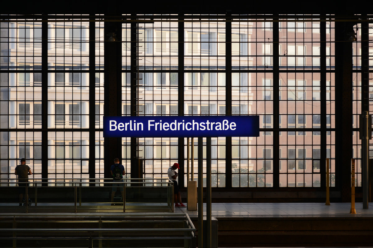 Bahnhofsschild auf dem Bahnsteig von Berlin Friedrichstraße. Aufnahme: 9. Juni 2019.