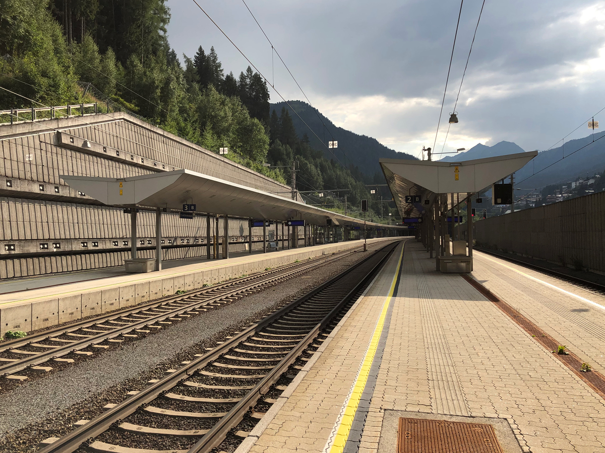 Bahnhofsübersicht mit tiefer Sonneneinstrahlung in St. Anton am Arlberg. Aufgenommen am Abend des 24.08.2019