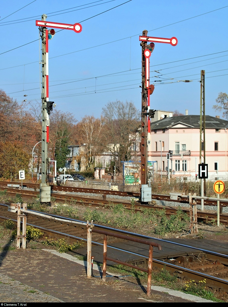 Bahnhofsumbau in Köthen: Eindrücke der historischen Anlagen in ihren letzten Monaten...
Blick auf zwei Formsignale auf Gleis 5 und Gleis 6, die leider auch bald weichen müssen.
Aufgenommen am Ende des Bahnsteigs 4/5.
Hauptsächlich von Juni bis Dezember 2019 werden einige bahntechnische Anlagen in und rund um den Bahnhof erneuert. Ein elektronisches Stellwerk (ESTW) soll künftig die vorhandenen Stellwerke ersetzen. Im Zuge dessen folgen bis zum Ende der 2020er-Jahre weitere Instandsetzungen entlang der Bahnstrecke Magdeburg–Leipzig (KBS 340) zwischen Zöberitz und Köthen. Dann sollen auch Bahnsteige und Brücken unter Berücksichtigung des Denkmalschutzes ertüchtigt werden.
Diese Maßnahmen ziehen zunächst eine sechsmonatige Vollsperrung mit sich. Bereits ab dem 5.5.2019 ist die Ein- und Ausfahrt Richtung Bernburg gesperrt.
[17.11.2018 | 12:09 Uhr]