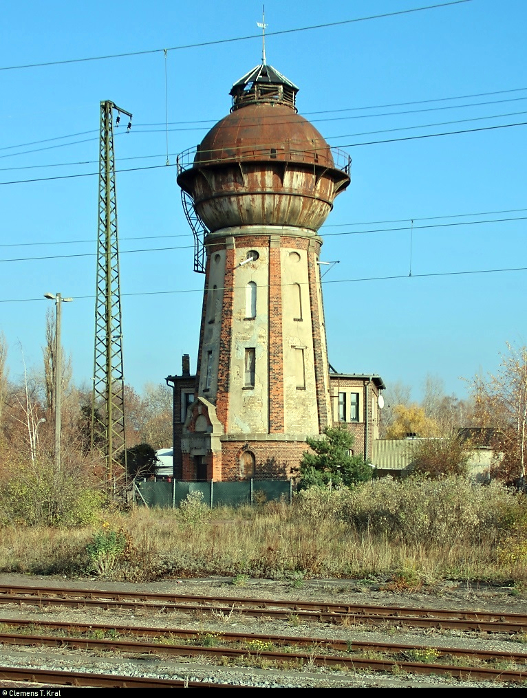 Bahnhofsumbau in Köthen: Eindrücke der historischen Anlagen in ihren letzten Monaten...
Blick auf einen Wasserturm im ehemaligen Bahnbetriebswerk Köthen. Dieses Baudenkmal stammt aus dem ersten Drittel des 20. Jahrhunderts.
Hauptsächlich von Juni bis Dezember 2019 werden einige bahntechnische Anlagen in und rund um den Bahnhof erneuert. Ein elektronisches Stellwerk (ESTW) soll künftig die vorhandenen Stellwerke ersetzen. Im Zuge dessen folgen bis zum Ende der 2020er-Jahre weitere Instandsetzungen entlang der Bahnstrecke Magdeburg–Leipzig (KBS 340) zwischen Zöberitz und Köthen. Dann sollen auch Bahnsteige und Brücken unter Berücksichtigung des Denkmalschutzes ertüchtigt werden.
Diese Maßnahmen ziehen zunächst eine sechsmonatige Vollsperrung mit sich. Bereits ab dem 5.5.2019 ist die Ein- und Ausfahrt Richtung Bernburg gesperrt.
[17.11.2018 | 12:12 Uhr]