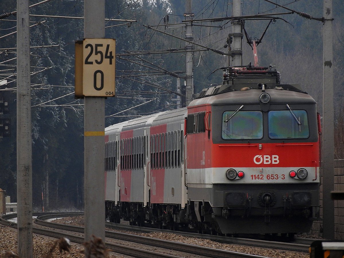 Bahnkilometer 254-0 an der Westbahn im Bereich Timelkam, 
und mittendrin die 1142 653-3, 
welche REX3096 dem Ziel entgegenschiebt; 170102