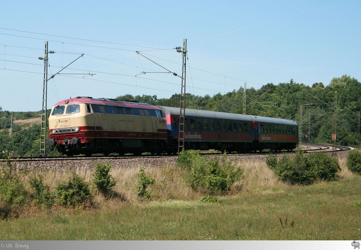 BahnTouristikExpress 217 002-5 ist mit zwei Personenwagen am 26. August 2015 bei Laaber in Richtung Regensburg unterwegs.