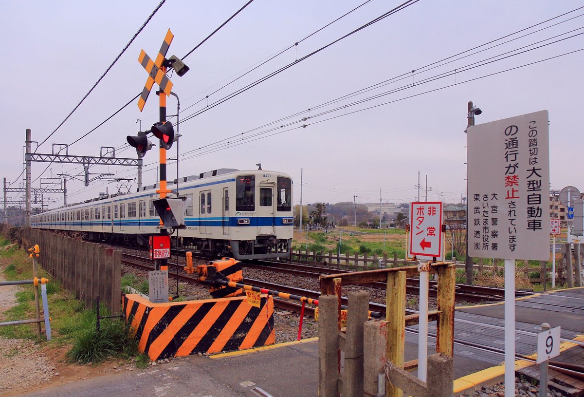 Bahnbergang auf der Strecke des Tbu-Konzerns bei miya Ken. Warntafeln, dass hier nur kleine Autos passieren drfen, ferner Hinweise zum Notknopf; auch zu sehen ist der beleuchtete Pfeil, der anzeigt, aus welcher Richtung ein Zug kommt. Tbu-S-Bahnzug Nr. 8171 aus dem Jahre 1976 passiert den Uebergang. 30.Mrz 2019 