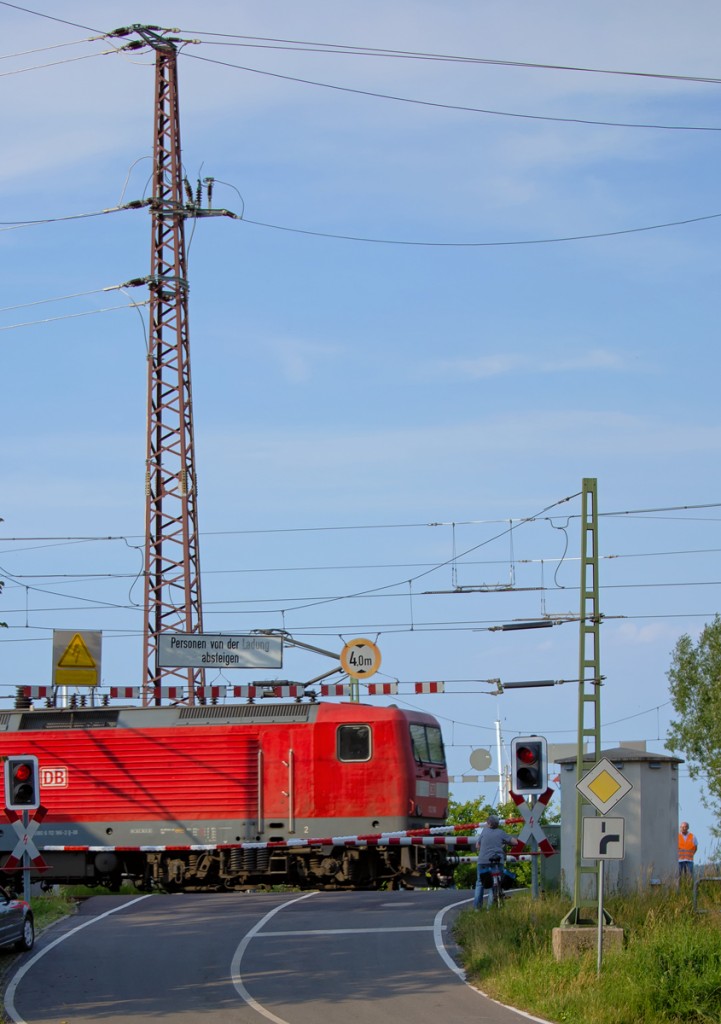 Bahnübergang Peeneklappbrücke Ankam (Pkb) wurde zusätzlich mit einem Absperrband durch den BÜP im Hintergrund gesichert, bevor der RE 3 (Lok BR 112) nach Stralsund diesen BÜ befuhr. - 29.06.2015