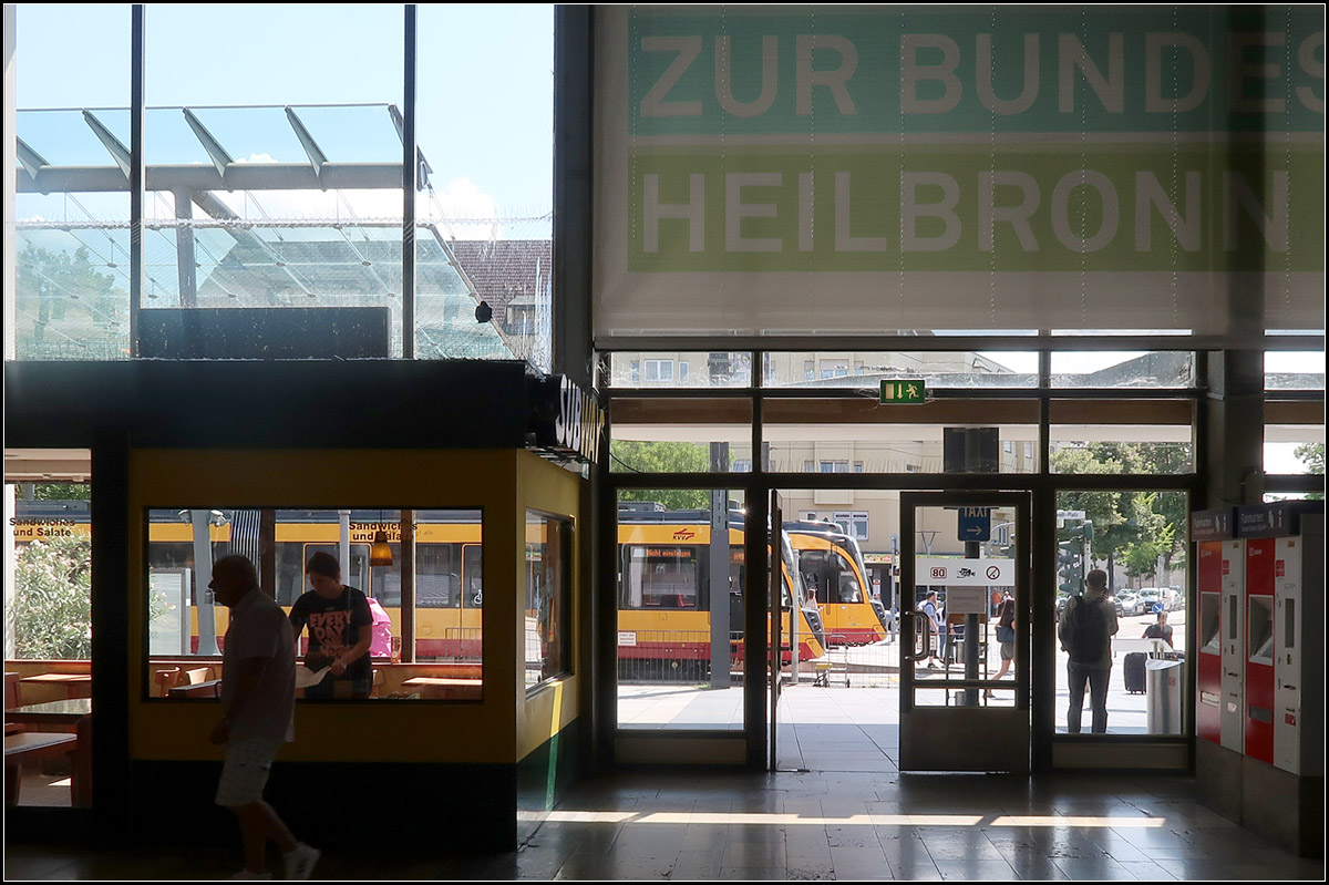 Bahnverkehr vor dem Bahnhof -

Am Heilbronner Hauptbahnhof wird ein großer Teil des regionalen Verkehrs vor dem Bahnhof abgewickelt. Dort fahren die Stadtbahnlinien nach Eppingen-Karlsruhe, Öhringen, Mosbach und nach Sinsheim.

Blick vom Bahnhofsgebäude hinaus auf die Stadtbahnhaltestelle mit zwei Mehrsystemzügen.

01.08.2019 (M)