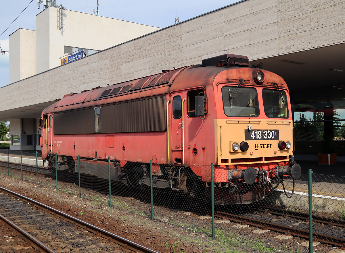 Balatonfüred: Uebergang von der elektrischen zur dieselbetriebenen Strecke. Die Diesellok wartet auf den Zug aus Budapest, um diesen anschliessend nach Tapolca zu bringen. Das Foto wurde vom Bahnsteig aus gemacht. Balatonfüred, 15.6.2023