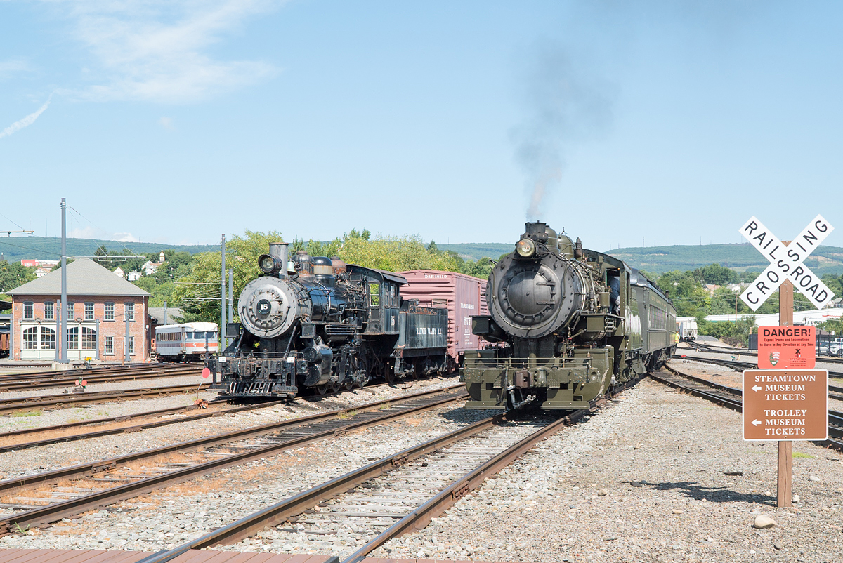 Baldwin #26 (rechts) führt am 06.08.2022 ihren kurzen Personenzug über das Bw-Gelände der Steamtown National Historic Site in Scranton, PA.
Links steht RV #15 mit einem kurzen Güterzug.