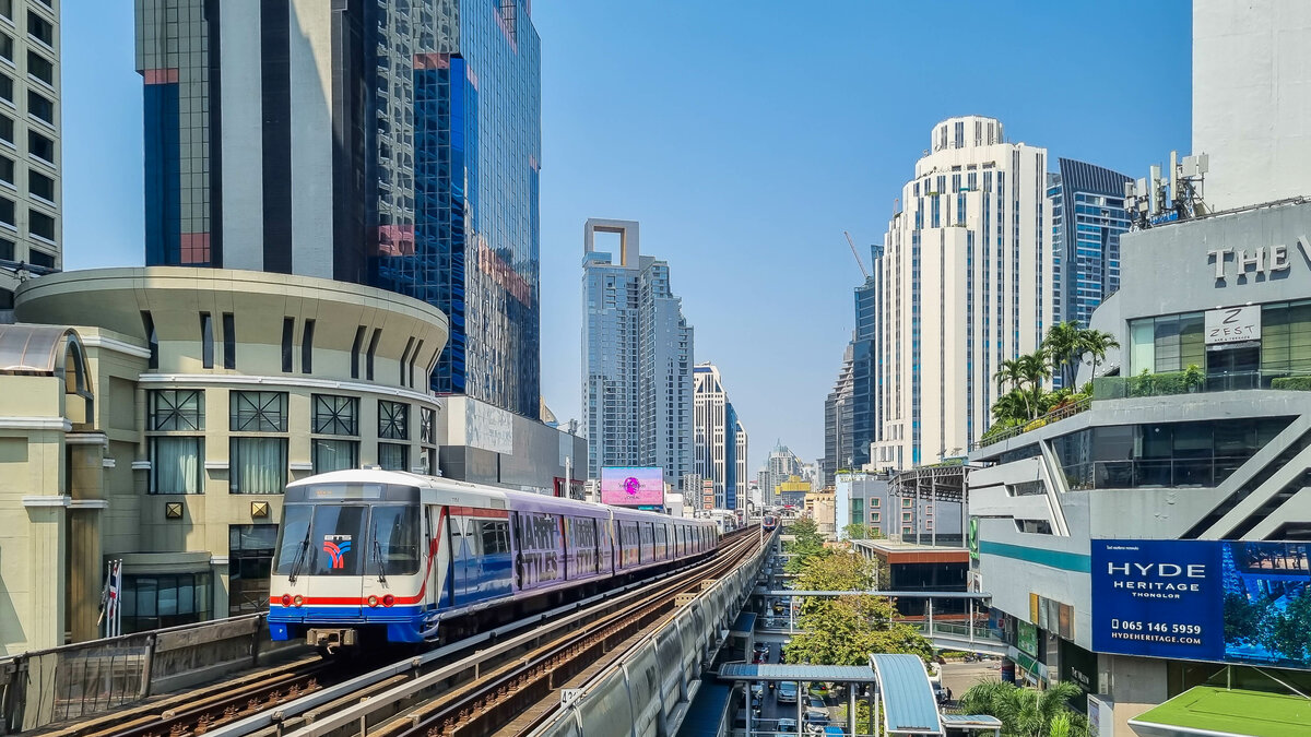 Bangkok BTS Skytrain Zug 1104 der Sukhumvit Line in Richtung Khu Khot bei der Ausfahrt aus der Station Chit Lom, 21.02.2023.