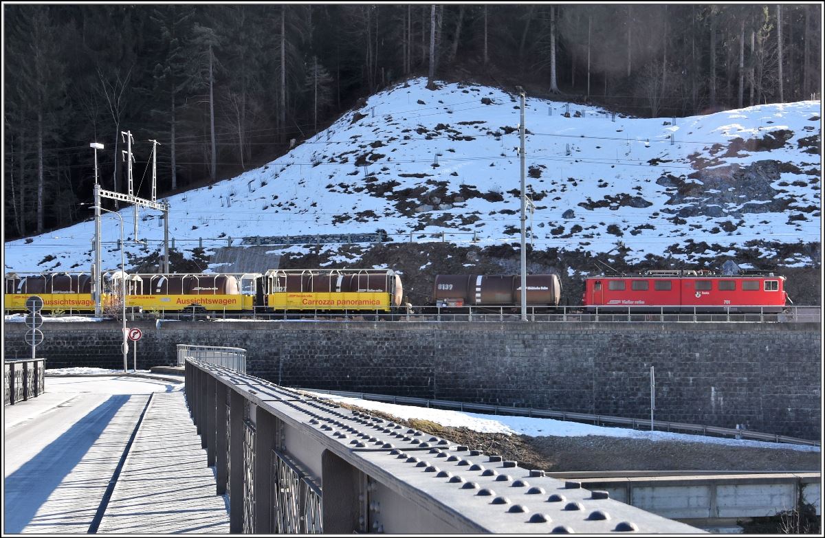 Bau der 2. Hinterrheinbrücke in Reichenau-Tamins. Ge 6/6 II 701  Raetia  mit vier Zisternenwagen passiert drei abgestellte Panoramawagen in Reichenau-Tamins. (13.02.2018)