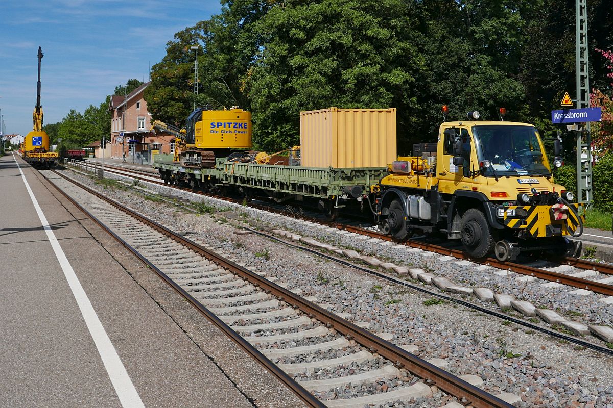 Bauarbeiten zur Elektrifizierung der Bodenseegrtelbahn, Streckenabschnitt Friedrichshafen - Lindau. Mittagspause im Bahnhof Kressbronn am 20.09.2019. Zweiwege-Unimog U 400 (99 80 9908 008-2D-ABRRS), Flachwagen, eine Waggonramme und eine selbstfahrende Ramme von SPITZKE.