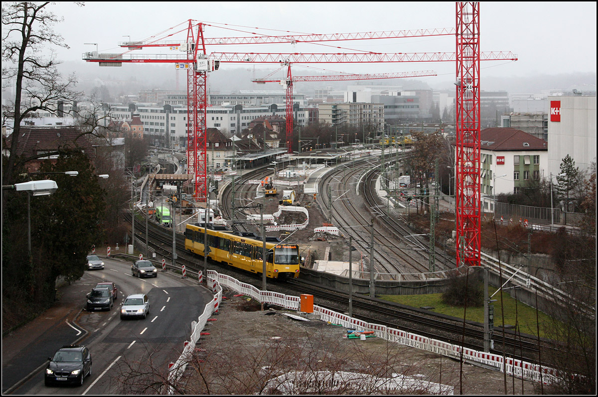 Baustelle Bahnhof Feuerbach, update -

Blick auf den Bahnhof Stuttgart-Feuerbach, wo zukünftig der Fern- und Regionalverkehr in den Tunnel zum neuen Hauptbahnhof verschwinden werden. Das S-Bahngleis in Fahrtrichtung stadtauswärts wurde vorübergehend auf die im Bild rechte Seite des Mittelbahnsteiges verlegt, um das Baufeld für den an die geplante Rampe anschließenden Tunnel frei zu machen. Die Rampe wird im Bereich der beiden Gleise rechts des Mittelbahnsteiges liegen. Das Gleis ganz rechts ist ein neu gebautes Umfahrungsgleis (stadtauswärts) für den Regional- und Fernverkehr. Bei der Mauer zwischen diesem und dem nächsten Gleis, dürfte es sich schon um eine Seitenwand der Rampe handeln. Da wo diese Mauer endet, müsste dann der Tunnel beginnen. Dieser verläuft dann in etwa in die linke untere Bildecke.

Unten passiert ein Zug der Linie U13 den Baustellenbereich.

14.01.2017 (M)