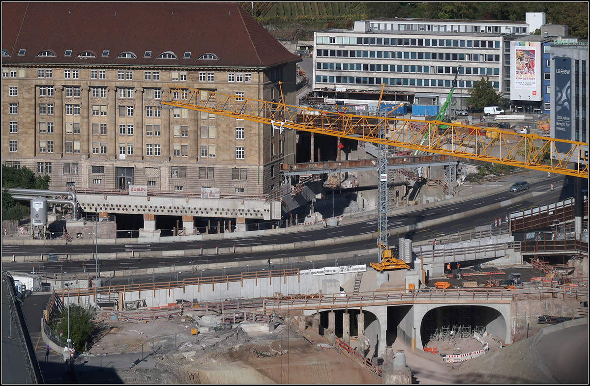 Baustelle des nördlichen Gleisvorfeldes -

Blick vom Stuttgarter Bahnhofsturm auf die Baustelle des neuen Bahnhofes. Unten die Tunnelportale zwischen dem Bahnsteigbereich und dem zukünftigen Gleisvorfeld unter der B27, dem alten Bahndirektionsgebäude und der Kriegstraße. Etwas links der Bildmitte hinter dem Dach des Direktonsgebäudes beginnen die bergmännisch aufgefahrenen Tunnels nach Bad Cannstatt und Feuerbach. Im Bereich der Bundesstraße muss noch der 2017 stillgelegte Stadtbahntunnel abgerissen werden, dieser ist den Bahngleisen im Weg.

12.12.2018 (M)