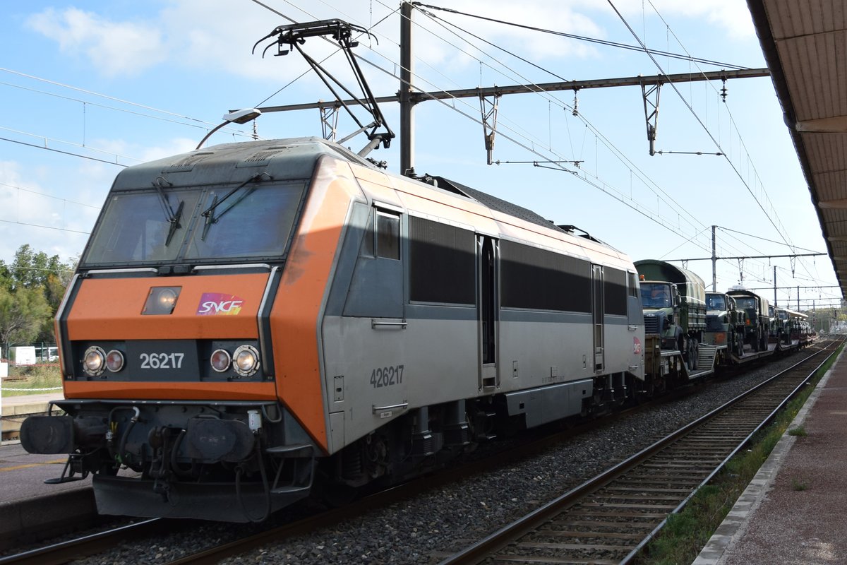 BB 26217 der SNCF mit einem Militärzug am Haken am 11.10.2018 bei der Durchfahrt in Arles (F.