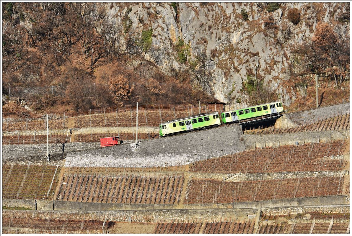 BDeh 4/4 312 + Bt362 befinden sich oberhalb Aigle auf dem Weg nach Leysin und passieren eine dort abgestellte und arbeitslose Schneeschleuder. (14.12.2016)