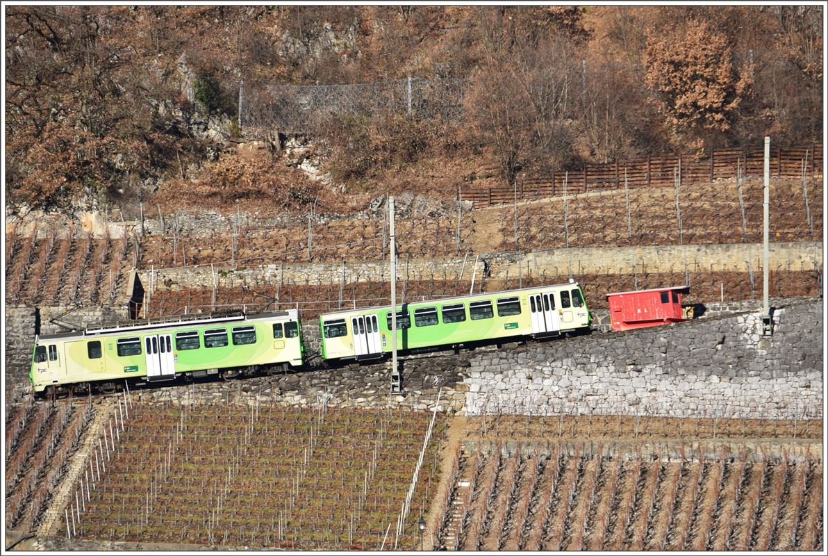 BDeh 4/4 312 + Bt362 befinden sich oberhalb Aigle auf dem Weg nach Leysin und passieren eine dort abgestellte und arbeitslose Schneeschleuder. (14.12.2016)