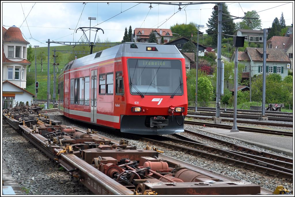 Be 2/6 631 bei der Einfahrt in Tavannes. Im Vordergrund stehen eine Reihe Rollschemel, mit denen mehrheitlich Schotter und Holz in normalspurigen Güterwagen transportiert werden, oder auch normalspurige Fahrzeuge für die Werkstätte in Tramelan. (12.05.2014)