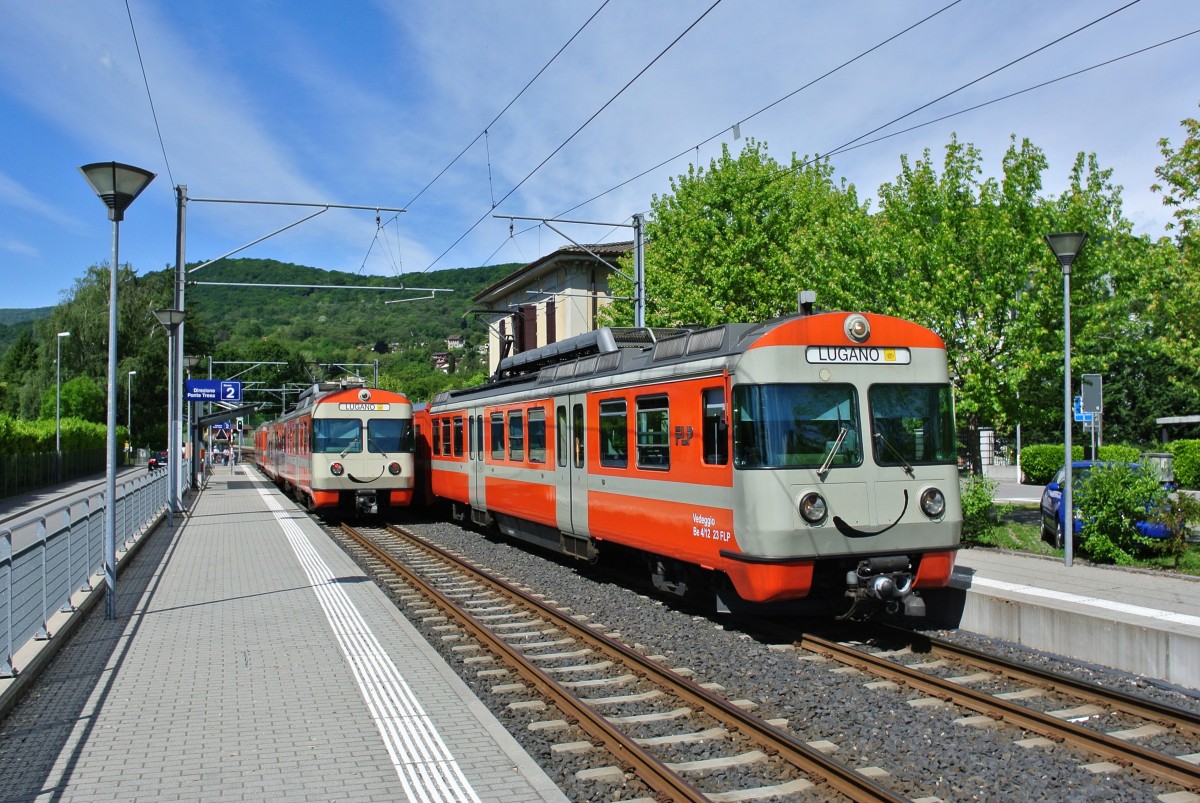 Be 4/12 22 (links, nach Ponte Tresa) und Be 4/12 23 (rechts, nach Lugano) bei der Kreuzung in Magliaso, 13.05.2014.