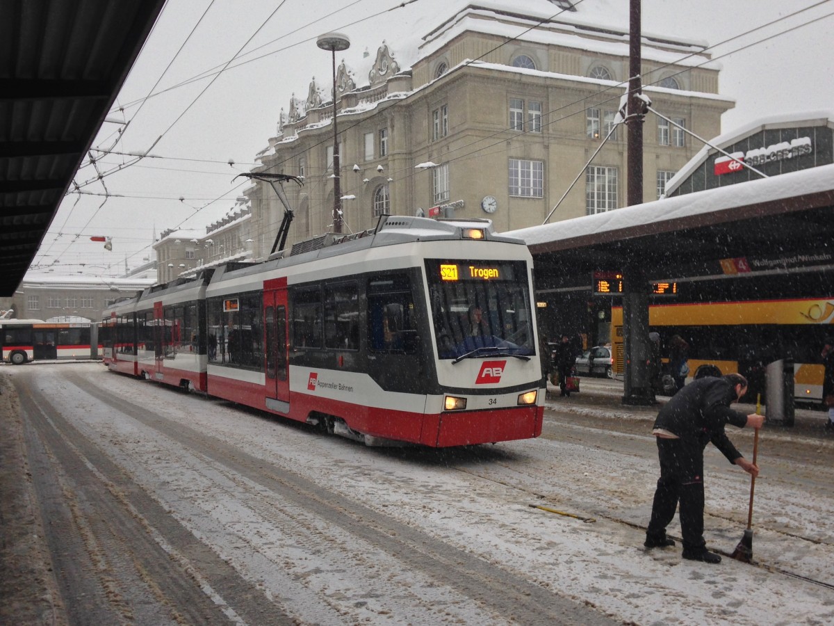 Be 4/8 Nr. 34 auf dem Bahnhofplatz in St. Gallen. Am 30.12.2014 gab es in der Ostschweiz einen heftigen Wintereinbruch, der Fahrplan konnte nicht mehr eingehalten werden, die Zge der TB hatten so Ihre Mhe. Doch auch Handarbeit war gefragt; ein MA der AB putzt die Weiche damit der Zug weiterfahren kann.