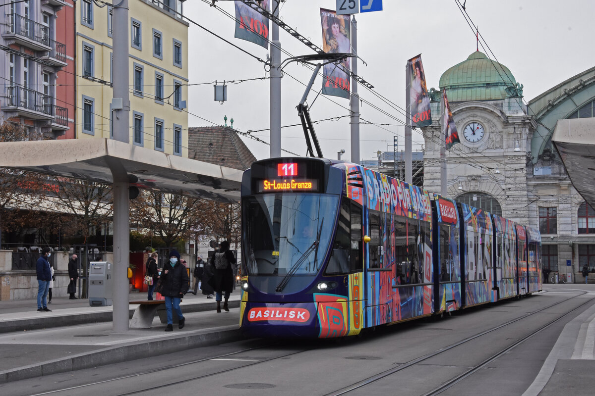 Be 6/10 Tango 185 mit der Werbung für das Basler Radio Basilisk, auf der Linie 11, bedient die Haltestelle Bahnhof SBB. Die Aufnahme stammt vom 23.11.2021.