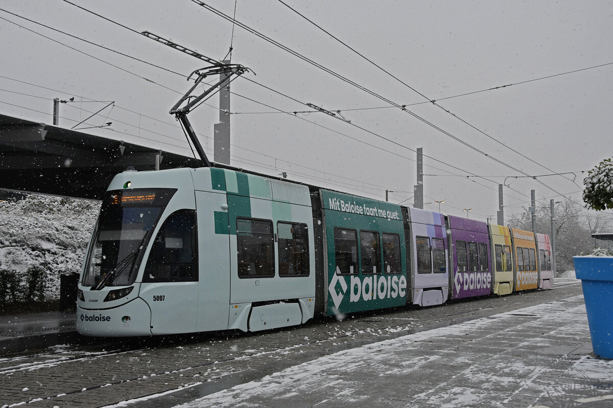 Be 6/8 Flexity 5007 mit der Baloise Werbung, auf der Linie 3, wartet am 09.12.2022 bei Schneefall an der Endstation beim Bahnhof Saint Louis.