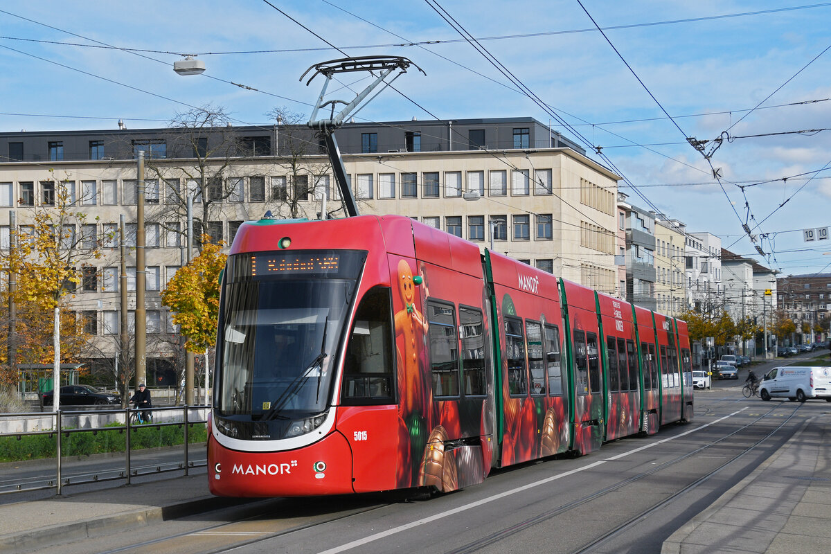 Be 6/8 Flexity 5015 mit der Manor Werbung, auf der Linie 1, wartet am 11.11.2025 an der Haltestelle Dreirosenbrücke. Aufnahme Basel.